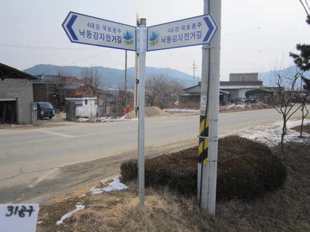 자전거 속도 변화가 큰 마을 우회 구간에 견고하게 세워진 표지판