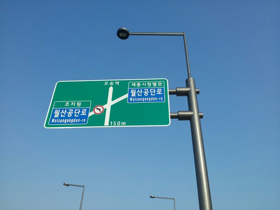 맑은 하늘 아래 시인성 높게 설치된 세종시 도로표지판 근접 사진