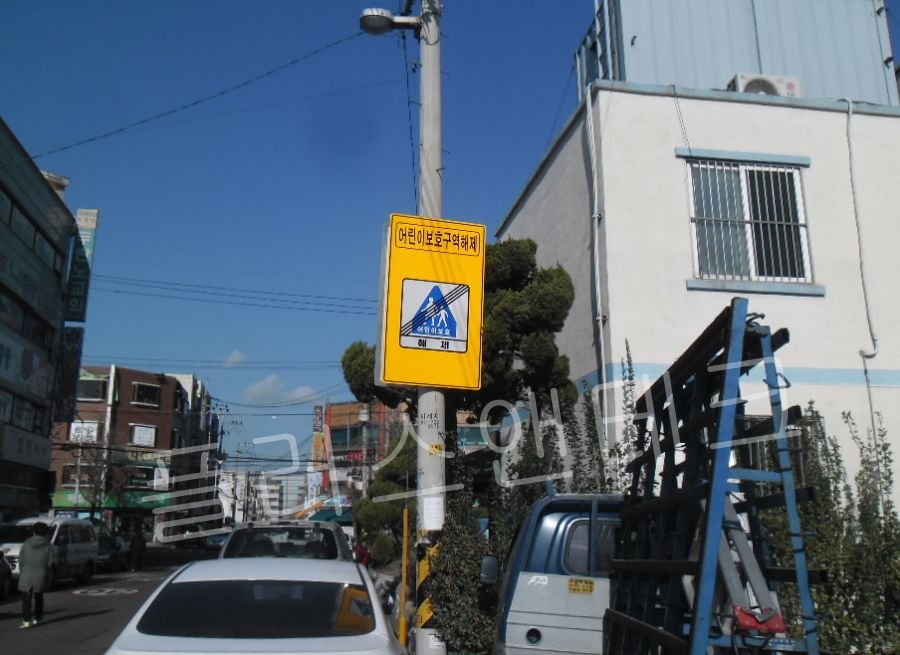 기존 전신주를 활용하여 고강도 스테인리스(SUS) 밴드와 전용 브라켓으로 튼튼하게 안내표지판 교체를 진행 중인 시공 과정.