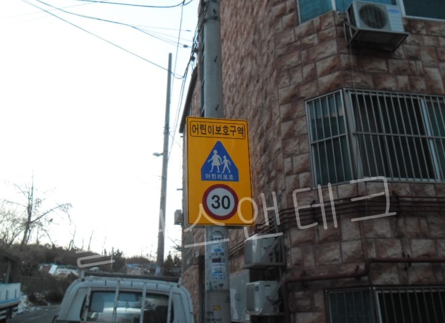 풍하중을 견디도록 전신주에 수직 수평을 정확하게 맞추어 이중 체결로 안내표지판 교체를 마감한 측면 상세 사진