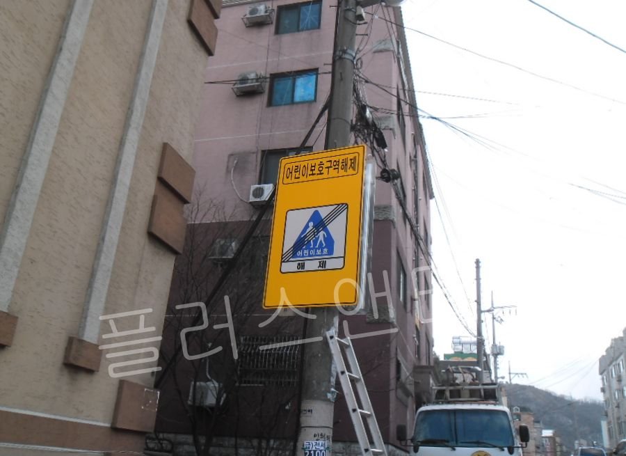 복잡한 도심지 전신주 지장물을 피하면서도 흔들림 없이 견고하게 고정된 해제 구간 안내표지판 교체 시공 완료 상태.