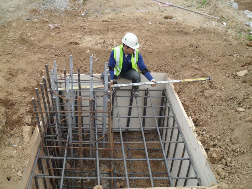 도로표지판 지주 기초 앙카의 수평을 규준대로 정밀하게 측정 중인 작업자