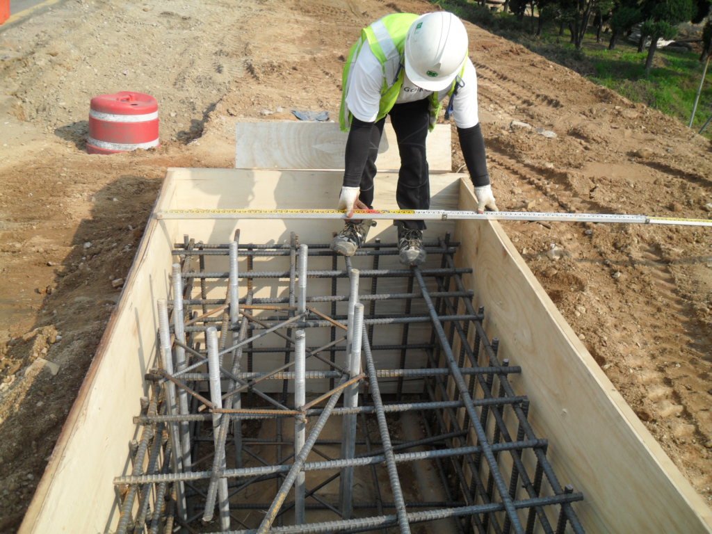 지주 기초 거푸집 폭과 앙카 볼트 간격을 줄자로 꼼꼼하게 검측하는 모습