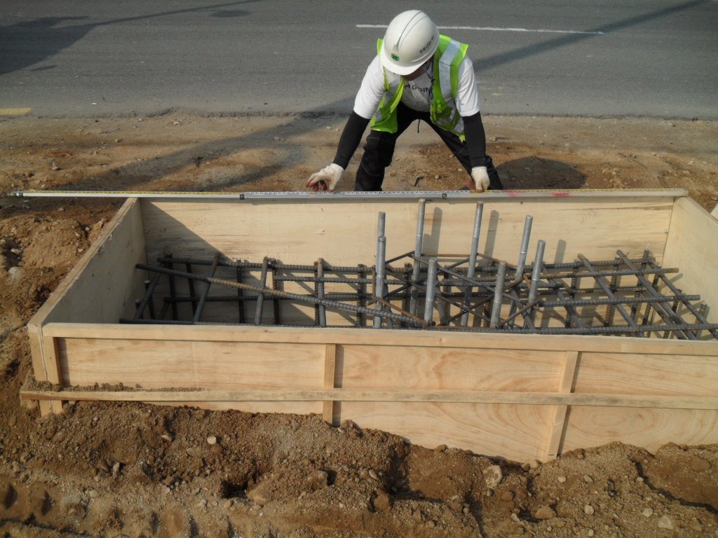기초 거푸집의 전체 길이 및 규격을 줄자로 정밀 확인하는 플러스앤테크 전문가