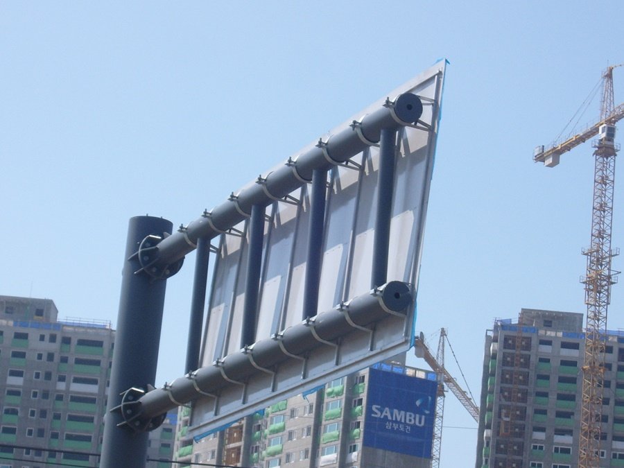 도로표지판 뒷면의 정밀한 볼트 너트 체결 및 브라켓 시공 근접 사진