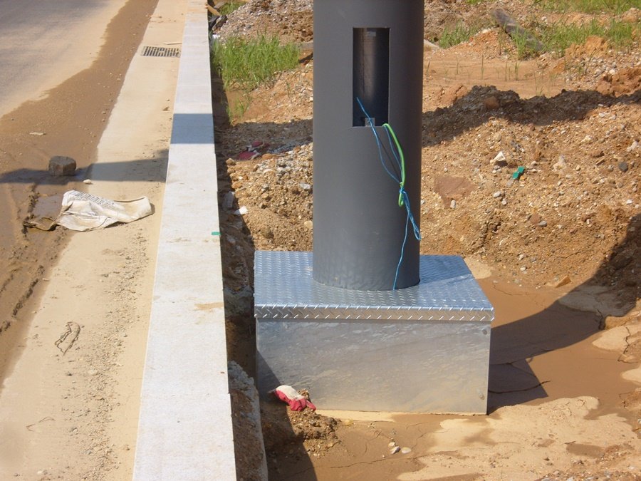 도로표지판 지주 하단부 전기 배선 점검구 및 콘크리트 기초 노출 상태