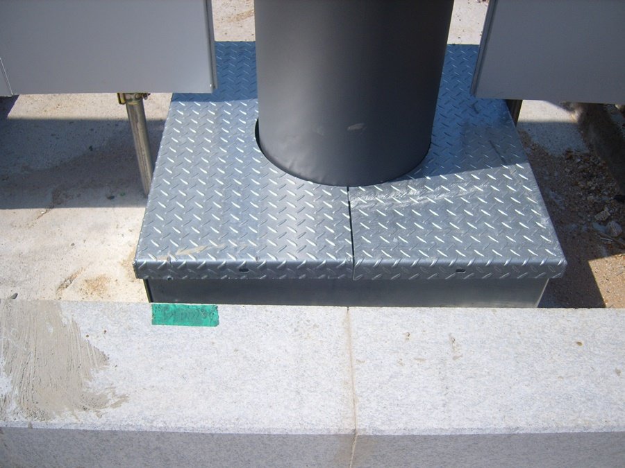 콘크리트 기초와 앙카 볼트를 안전하게 덮은 체크무늬 강판 커버 시공