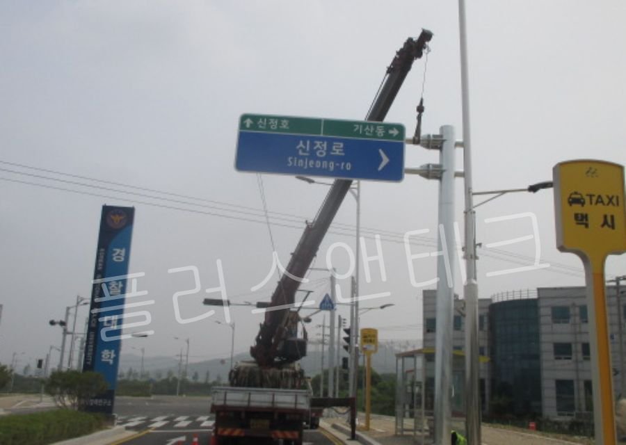 안전 통제 하에 크레인으로 중량물을 들어 올리며 오차 없는 수직/수평 레벨링을 맞추는 편지식 지주 시공 세부 공정.