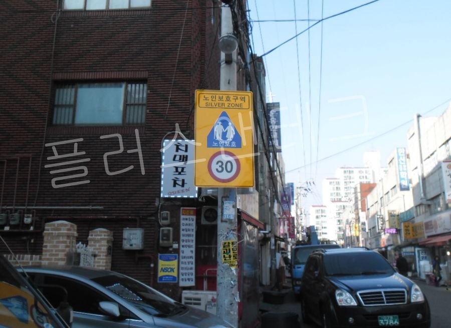 운전자의 시야각에 맞춰 수직 및 수평 정밀 레벨링 마감 작업이 완료된 선명한 노인보호표지판 설치 측면 전경.