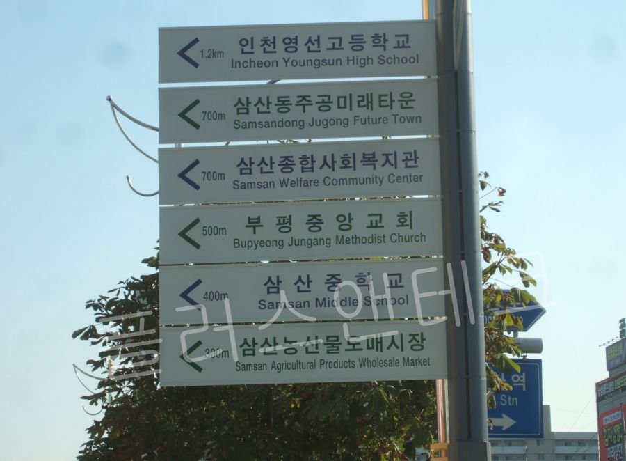 학교, 시장, 복지관 등 5개의 목적지 판넬이 용융아연도금 지주에 고강도 브라켓으로 견고하게 결속된 지주식 다방향 안내표지판 전경.