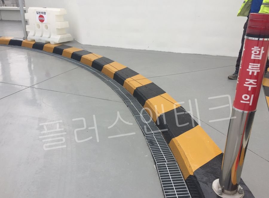 관공서 주차장 진출입로의 급커브 구간에서 차량 이탈 방지를 위한 앙카식 갈매기표지판 시공 전 현장 노면 상태.