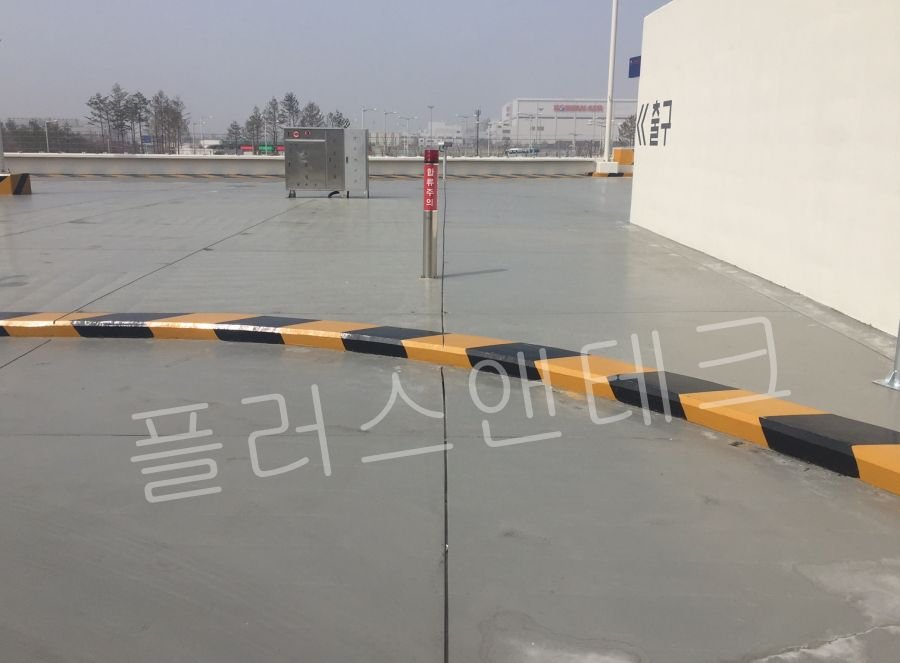 급커브 연석 라인을 따라 일정한 간격으로 용융아연도금 강관 지주 결속이 튼튼하게 완료된 갈매기표지판 시공 중간 단계.