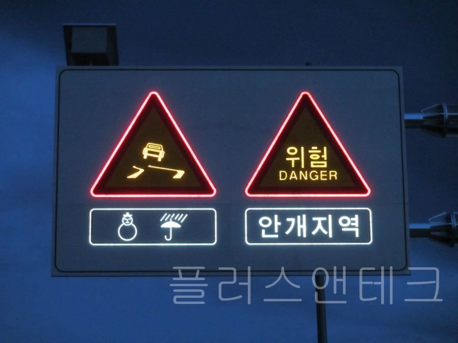 미끄럼 주의 및 안개지역 경고 문구를 짙은 안개 속에서도 뚜렷하게 전달하는 초고휘도 태양광 표지판 야간 발광 모습.