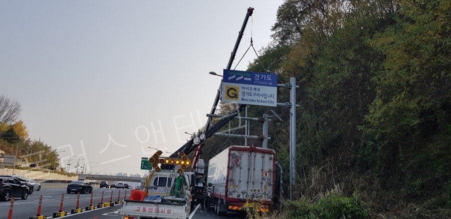 교통통제용 사인보드 차량의 안전 확보 하에 신규 태양광 발광형표지판을 크레인으로 인양하여 지주에 결속하는 공정