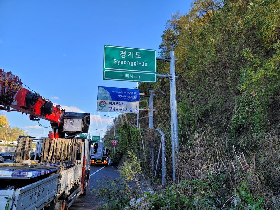 구리시 신내동 북부간선도로 현장에 도착한 기존 일반 반사지형 도로표지판과 철거를 준비 중인 플러스앤테크 크레인 차량 모습