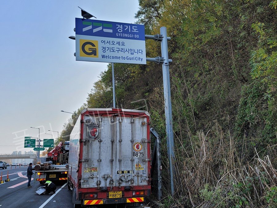 구리시 신내동 북부간선도로 변에 발광형표지판 설치를 최종 완료하고 주변 정돈 및 하부 점검을 진행 중인 플러스앤테크 시공팀