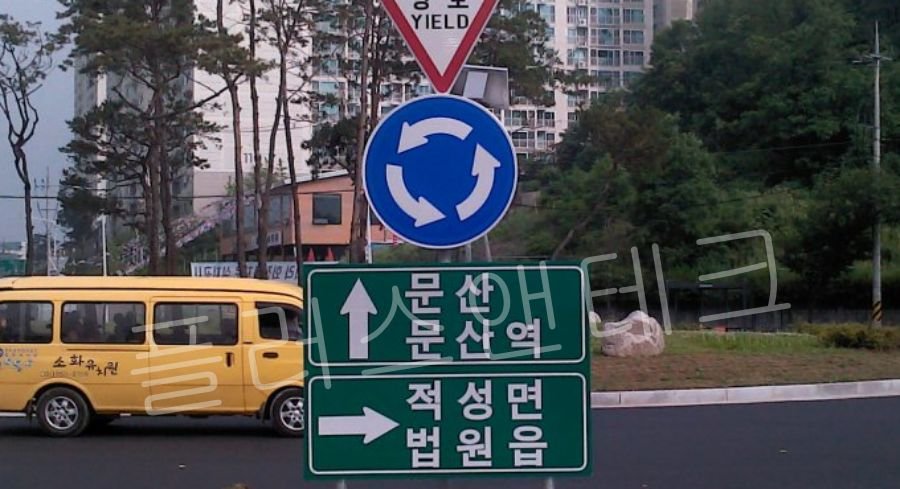 방향 안내 표지와 함께 지주에 복합적으로 안전하게 시공된 플러스앤테크 일반 반사형 회전교차로 표지판
