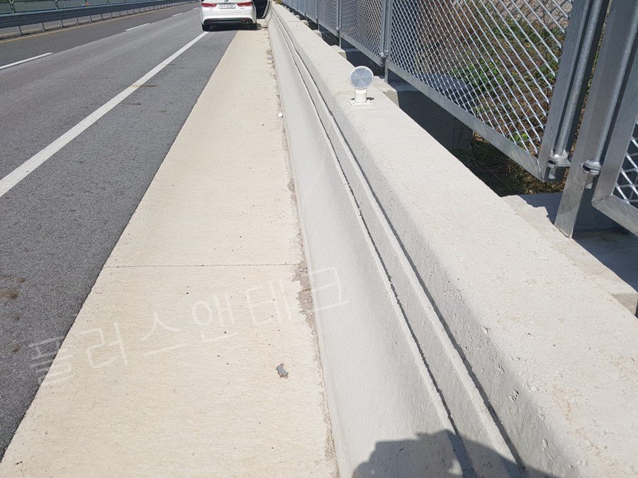 고속도로 하가리교 교량 구간 콘크리트 방호벽 상단에 고강도 앵커로 튼튼하게 결속된 플러스앤테크 신규 시선유도표지(델리네이터