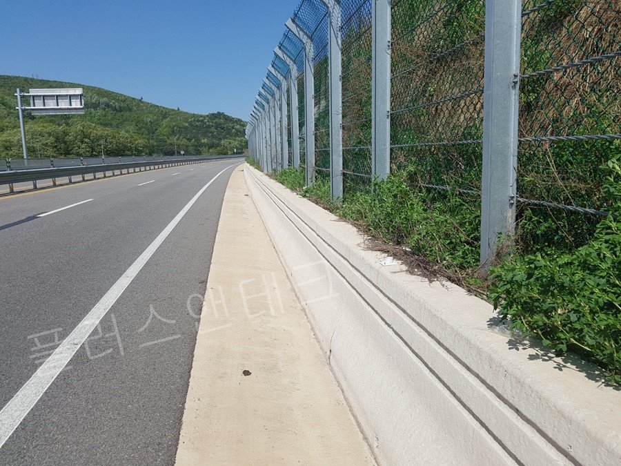 곡선 구간 콘크리트 방호벽 상단에 일정한 간격으로 튼튼하게 결속된 플러스앤테크 시선유도표지 하부 베이스 확인 작업