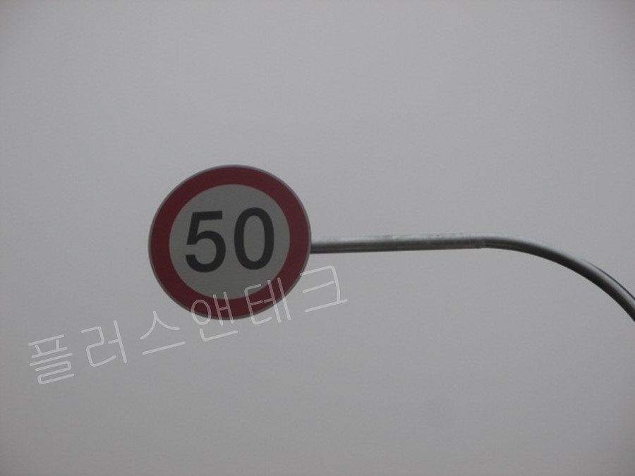 속도제한 50km/h 표지판의 근접 사진으로, 야간에도 빛을 반사하여 뚜렷하게 식별 가능한 고휘도 반사지 코팅과 정밀한 마감 상태를 보여주는 상세 컷