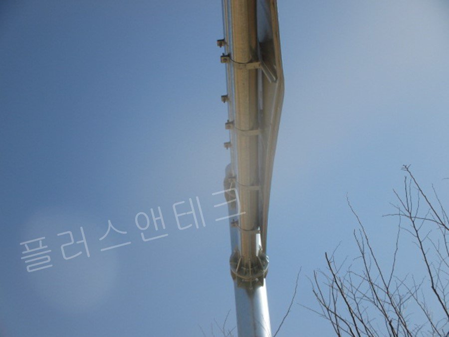 표지판 상부 구조물 하단에서 위를 올려다본 앵글로, 여러 개의 체결 밴드가 일정한 간격으로 지주와 판넬을 꽉 잡아주어 강풍에 의한 비틀림 하중을 분산시키는 견고한 설치 마감 디테일