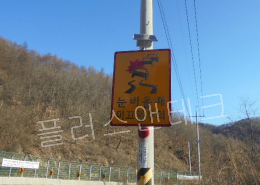 시공이 완벽하게 끝난 연천군 도로의 태양광 LED 결빙주의 표지판. 상단 태양광 패널과 눈 비 올 때 미끄럼주의라는 직관적인 문구가 선명하게 보이는 최종 완성 모습