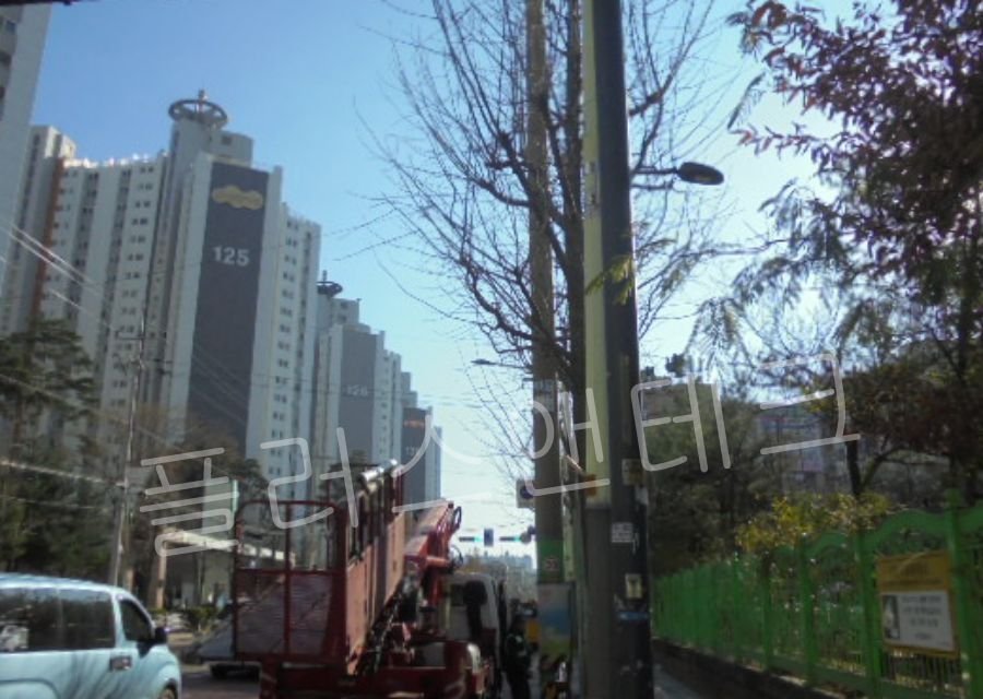 고소작업차량이 인천 서구 아파트 단지 인근 도로에 정차하여 어린이보호구역 표지판 설치 작업을 준비하는 모습