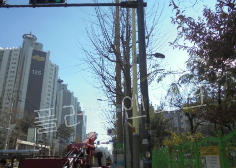표지판이 부착될 기존 가로등 지주의 상단부를 확인하며 크레인 작업대가 상승할 준비를 하는 모습