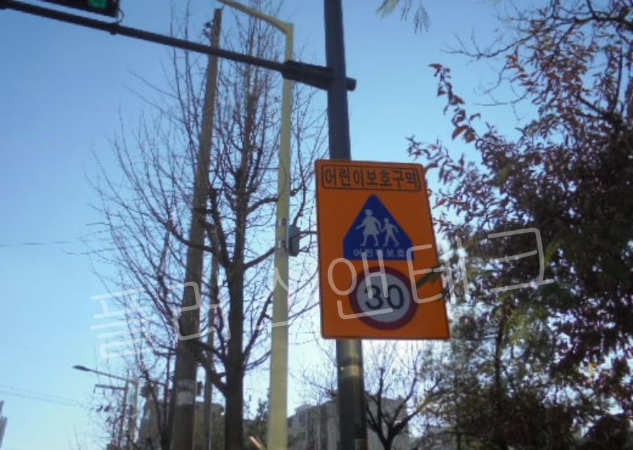 설치가 완료된 시인성 높은 황색 바탕의 30km 속도제한 어린이보호구역 안내표지판