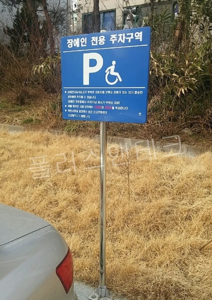 과태료 10만원 등 법적 처벌 조항이 상세히 명시된 장애인 전용 주차구역 표지판