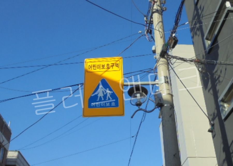 전주에 설치된 태양광 패널과 어린이보호구역 표지판 완성 후 전경, 맑은 하늘 배경