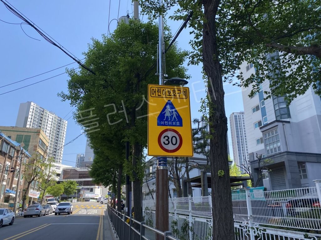 2지점 설치 후, 가로수 사이로 시인성이 확보된 어린이보호구역 표지판