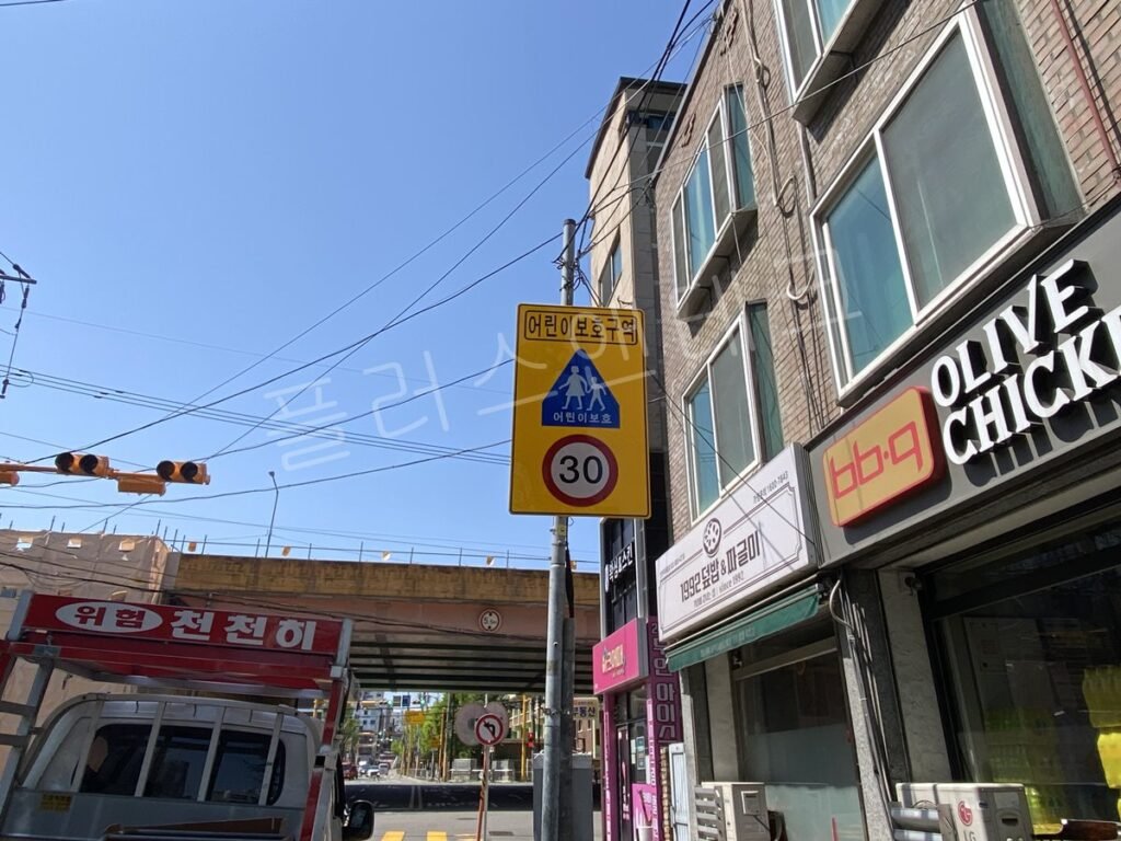 3지점 설치 후, 상가 교차로 전주에 부착된 어린이보호구역 표지판