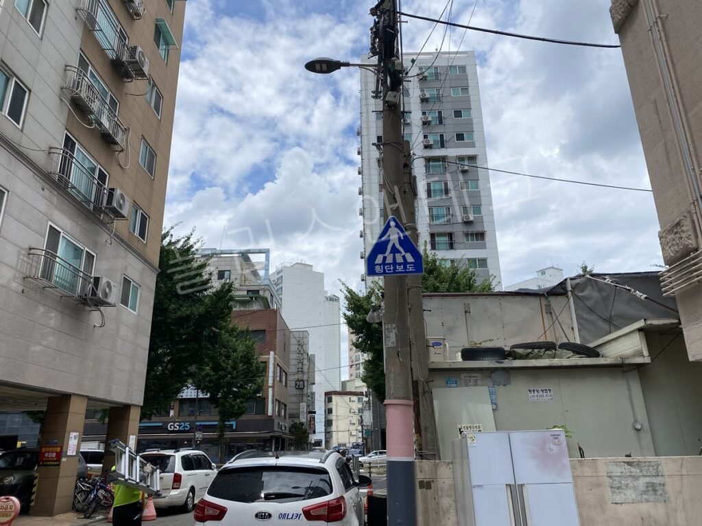횡단보도 예고 표지판이 병설된 교차로 진입부 가로등주 전경