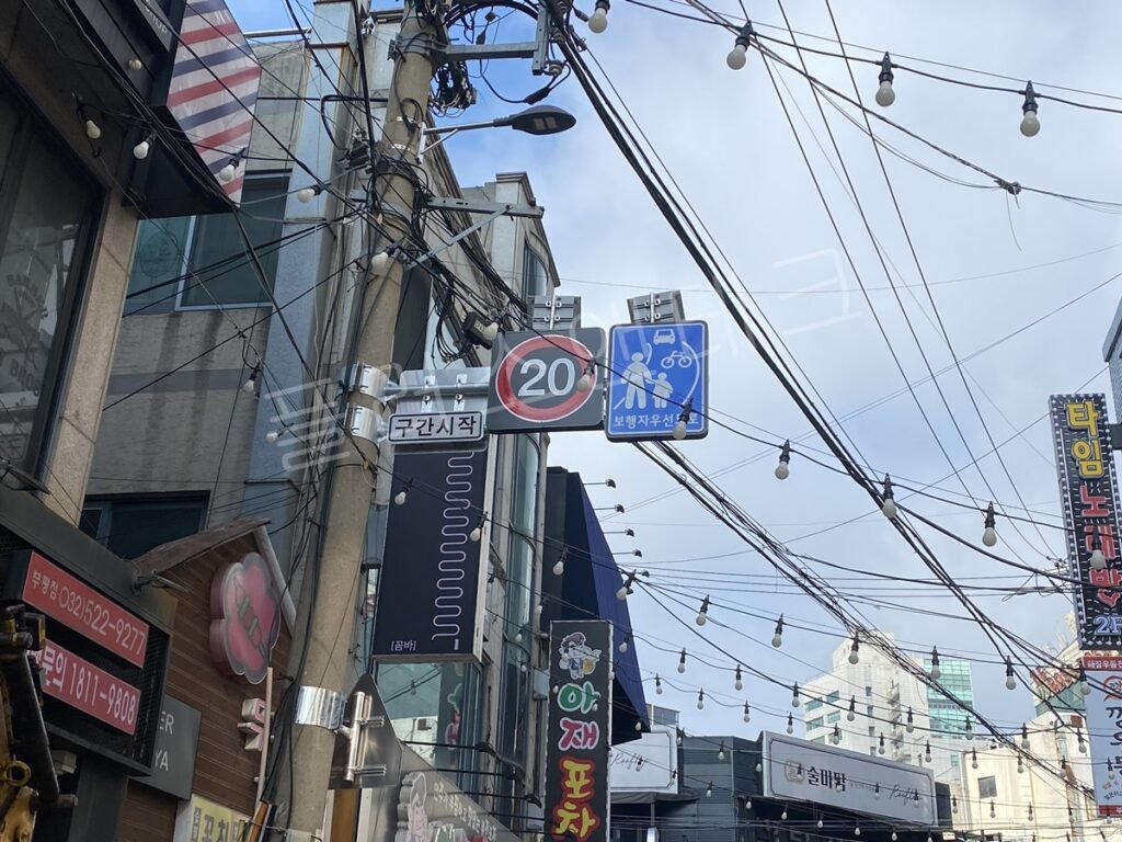 유흥상업지구 전주에 부착된 보행자우선도로 표지판 야간 시인성 확보 모습