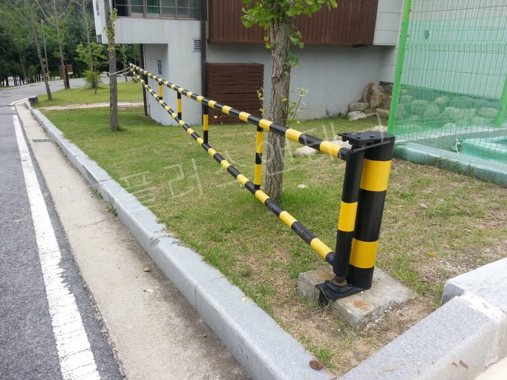 화단 옆에 단독으로 설치된 흑색과 황색이 교차하는 볼라드형 차단기
