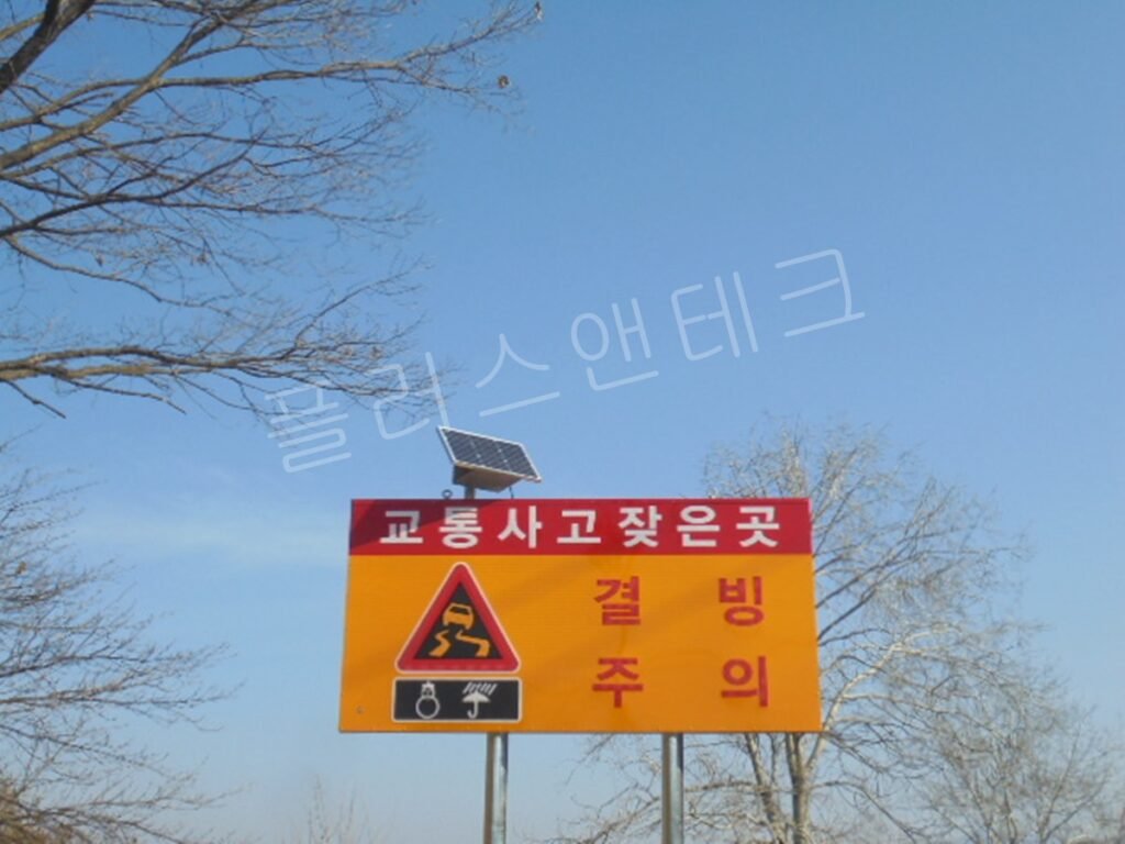 태양광 패널이 상단에 견고하게 부착된 표지판의 클로즈업 샷, 야간 시인성 확보를 위한 핵심 자가발전 장치