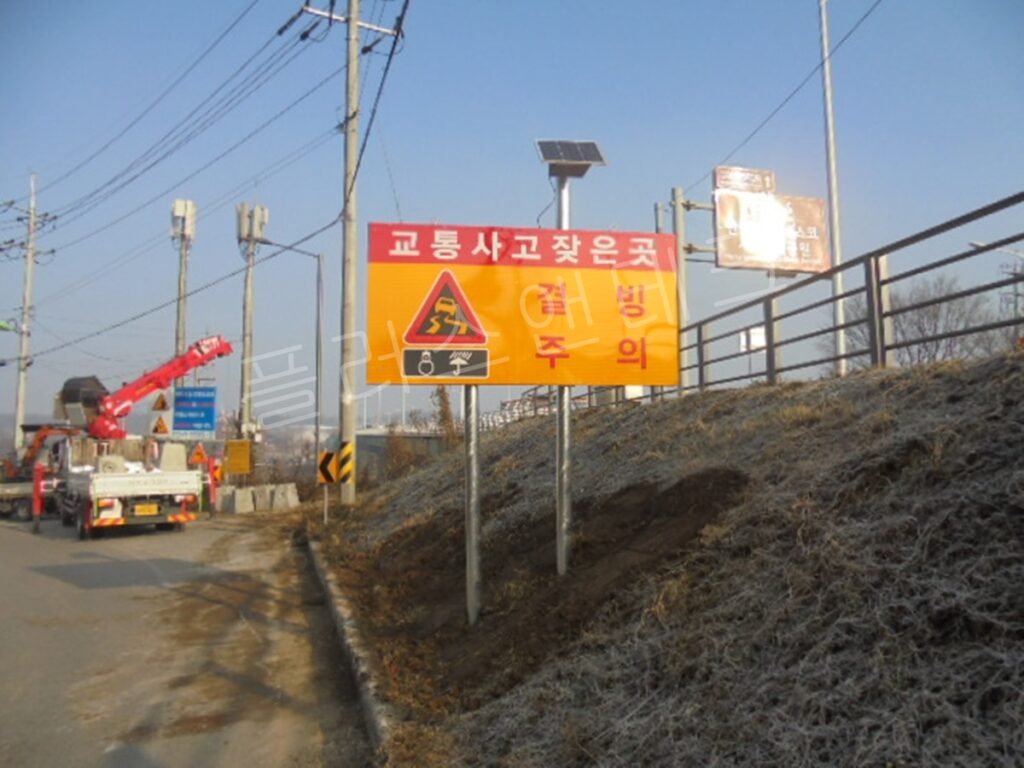 설치가 완료된 복주식 태양광 LED 결빙주의 표지판의 우측면 모습, 튼튼하게 고정된 지주와 깔끔하게 정리된 하단 토사 마감